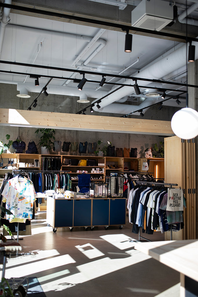 Inside Dapper's Nordre gate store with sunlight through the windows, racks of clothing and products on table displays.